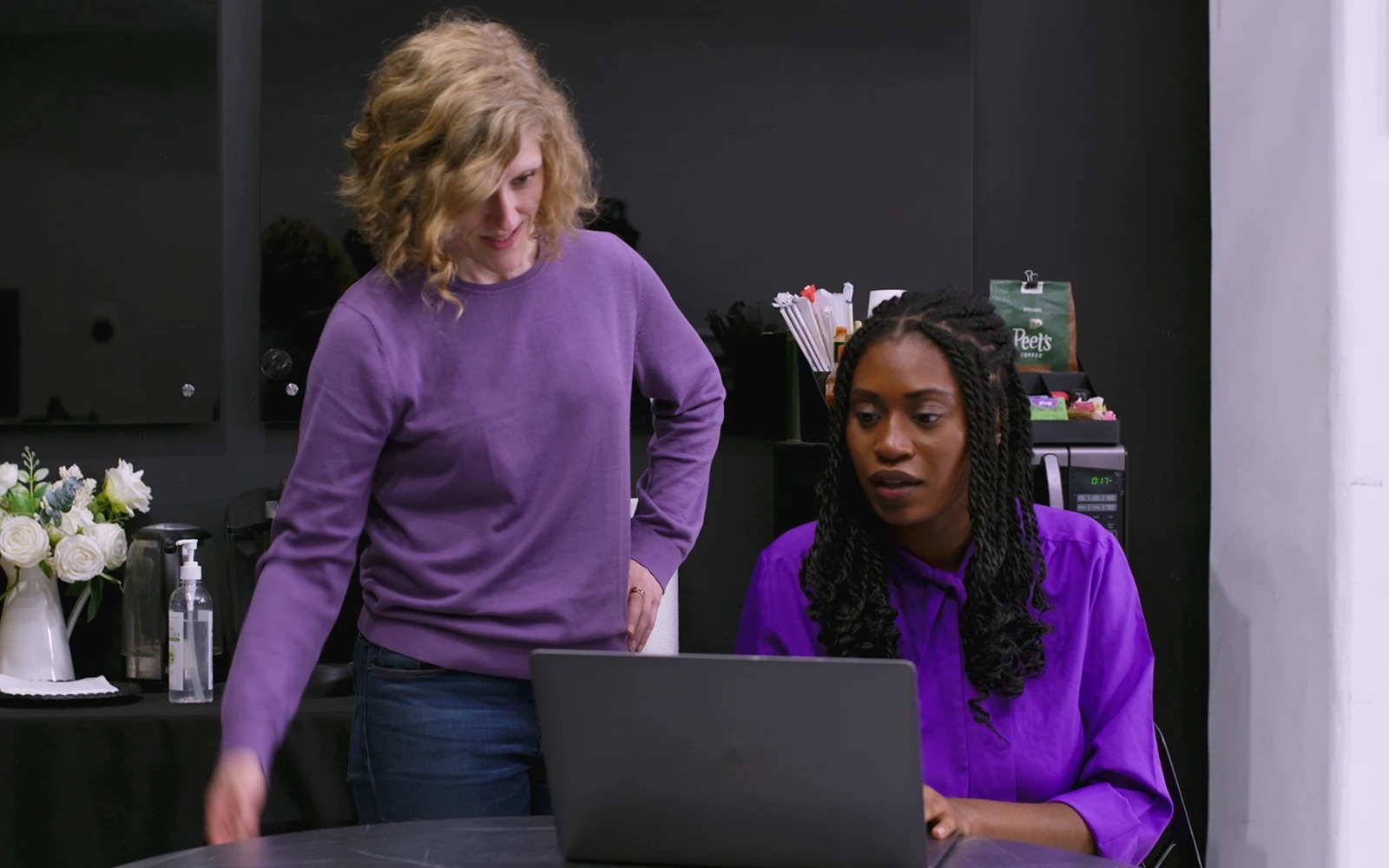 Two people reviewing work on a laptop