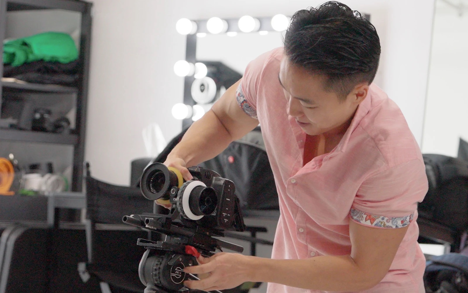 A camera operator setting up a rig on a tripod